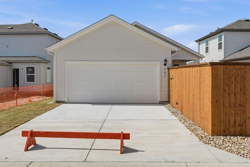 201 Betsy Road Hutto, TX 78634 - Photo 2 of 18 The property features a concrete driveway leading to an integrated garage with a white panel garage door