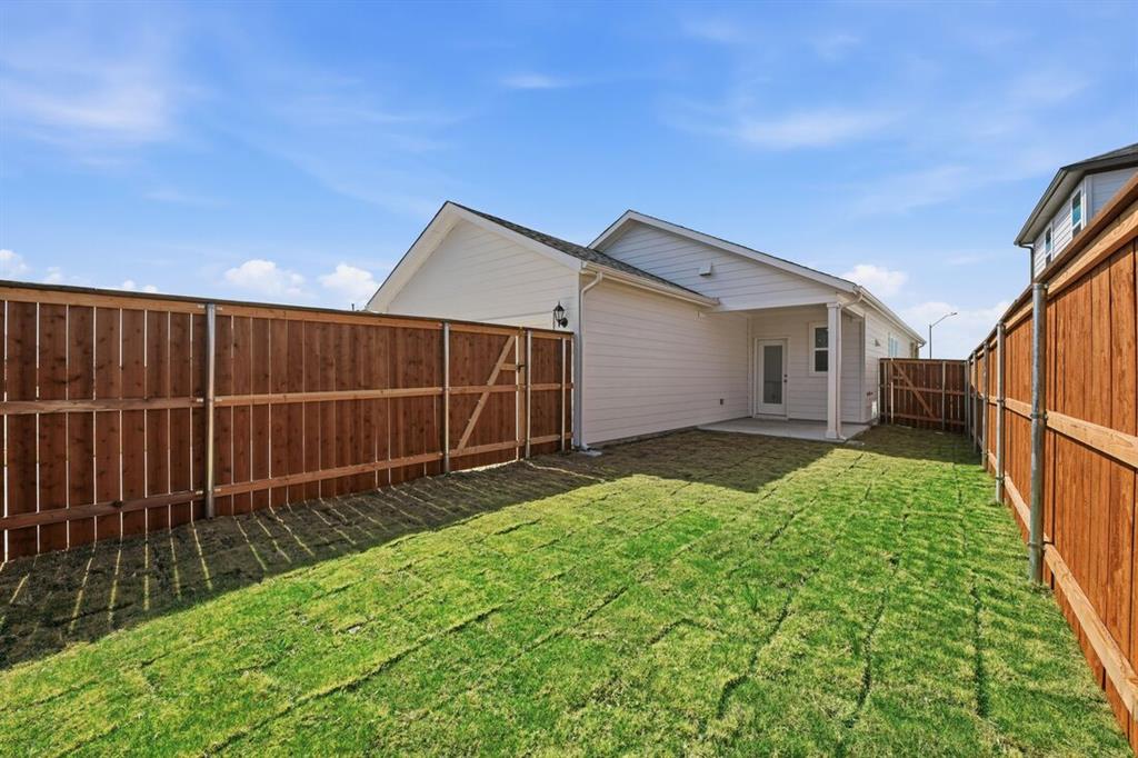 201 Betsy Road Hutto, TX 78634 - Photo 3 of 18 The property features a private backyard with a newly laid lawn, a covered patio, and a wood privacy fence
