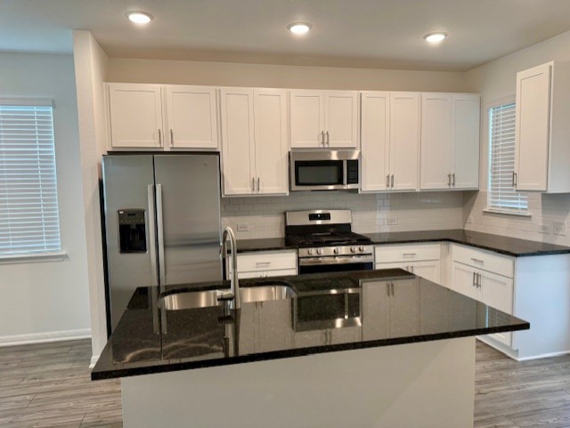 201 Betsy Road Hutto, TX 78634 - Photo 7 of 18 The kitchen features white cabinetry with brushed nickel hardware, stainless steel appliances, and dark countertops