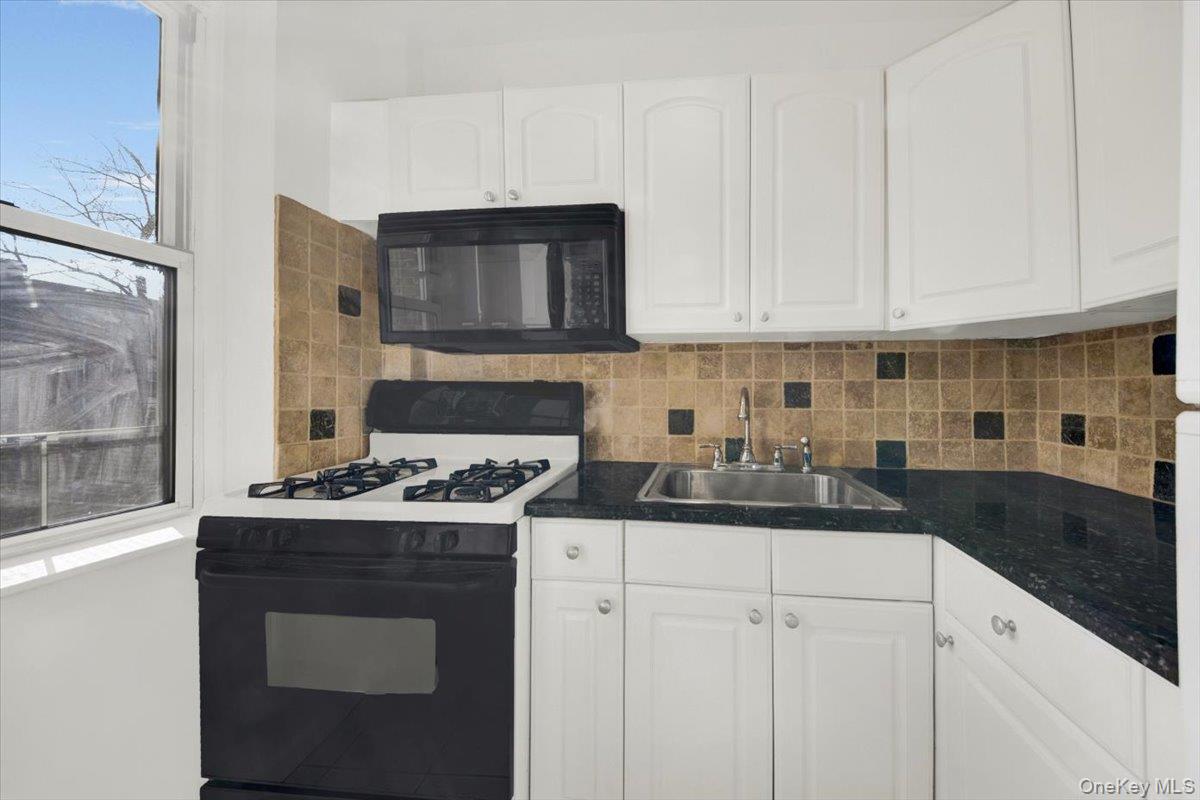 811 Bronx River Road, Unit 3C Bronxville, NY 10708 - Photo 15 of 27 a kitchen with a stove sink and cabinets