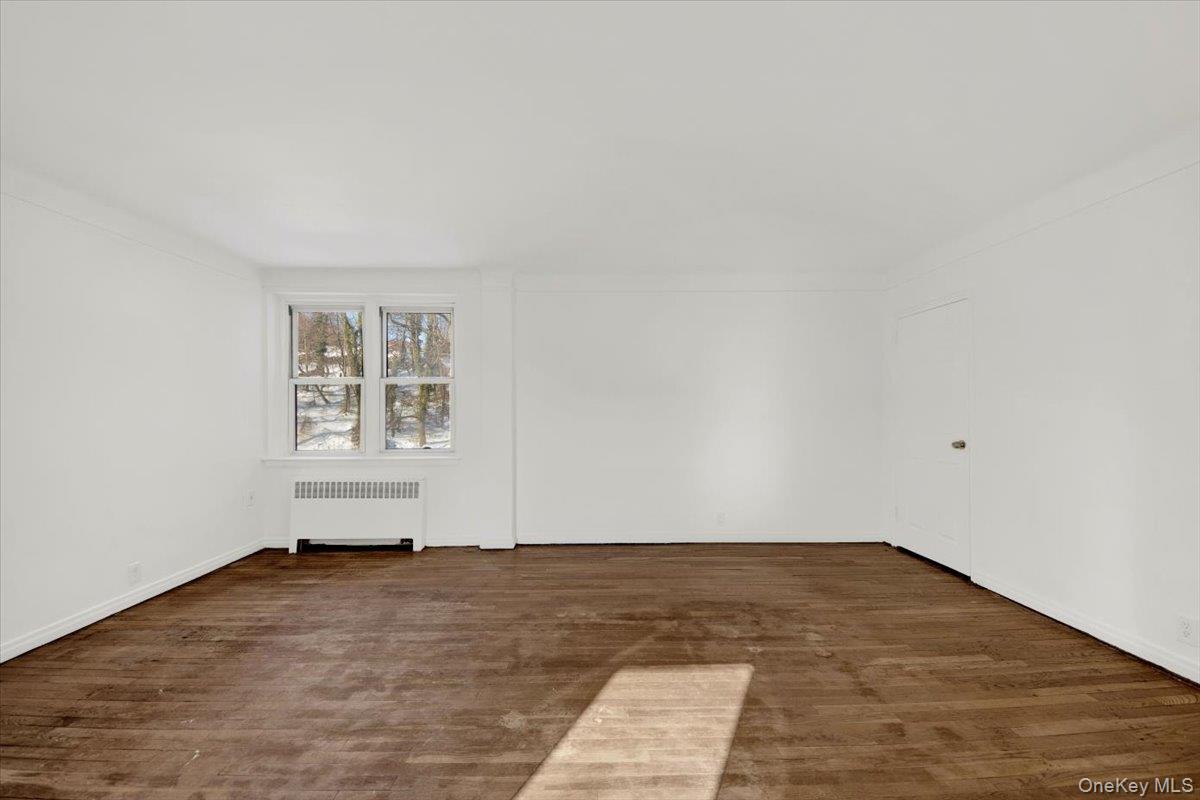 811 Bronx River Road, Unit 3C Bronxville, NY 10708 - Photo 20 of 27 an empty room with wooden floor and windows