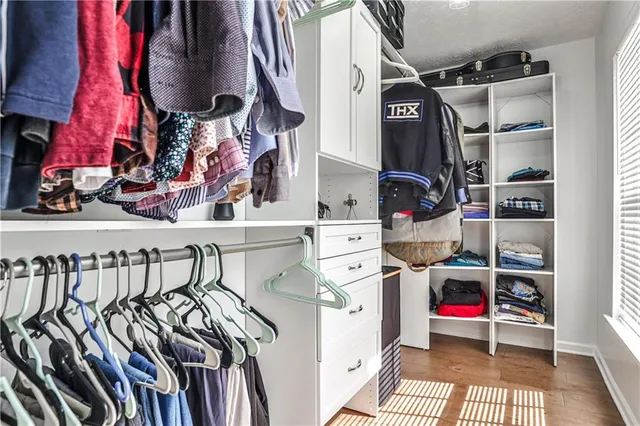 a view of walk in closet with clothes and shoes