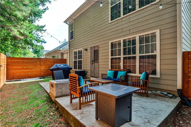 a backyard of a house with barbeque oven and large trees