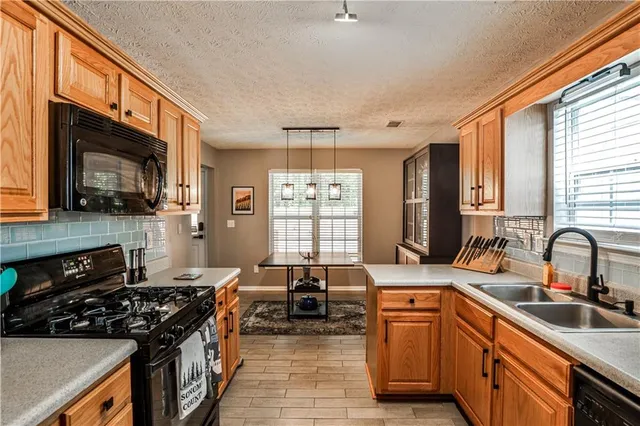 a kitchen with stainless steel appliances a sink stove and cabinets