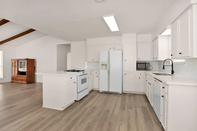 a kitchen with white cabinets and white appliances