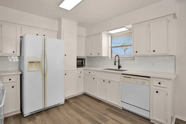 a kitchen with stainless steel appliances white cabinets and a refrigerator