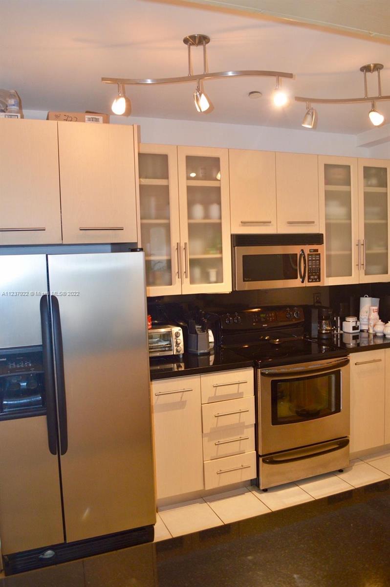 151 Crandon Boulevard, Unit 127 Key Biscayne, FL 33149 - Photo 14 of 30 a kitchen with stainless steel appliances granite countertop a refrigerator and a stove