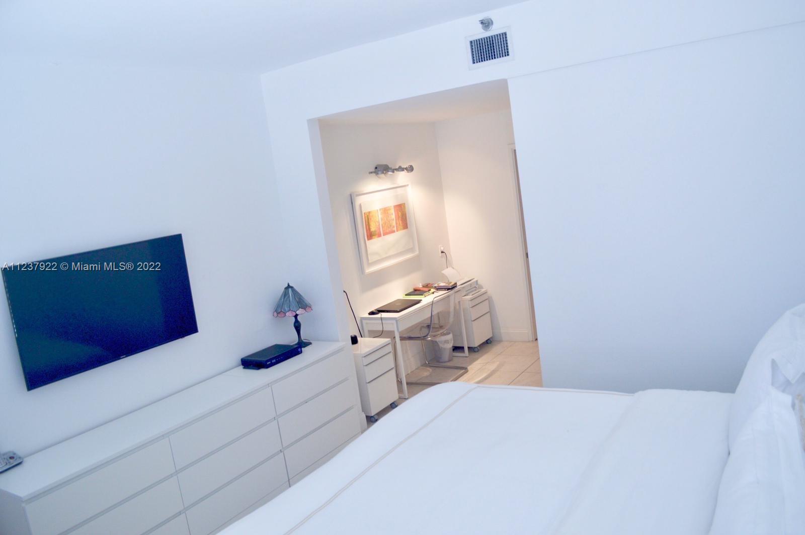 151 Crandon Boulevard, Unit 127 Key Biscayne, FL 33149 - Photo 21 of 30 a bedroom with a bed and a mirror