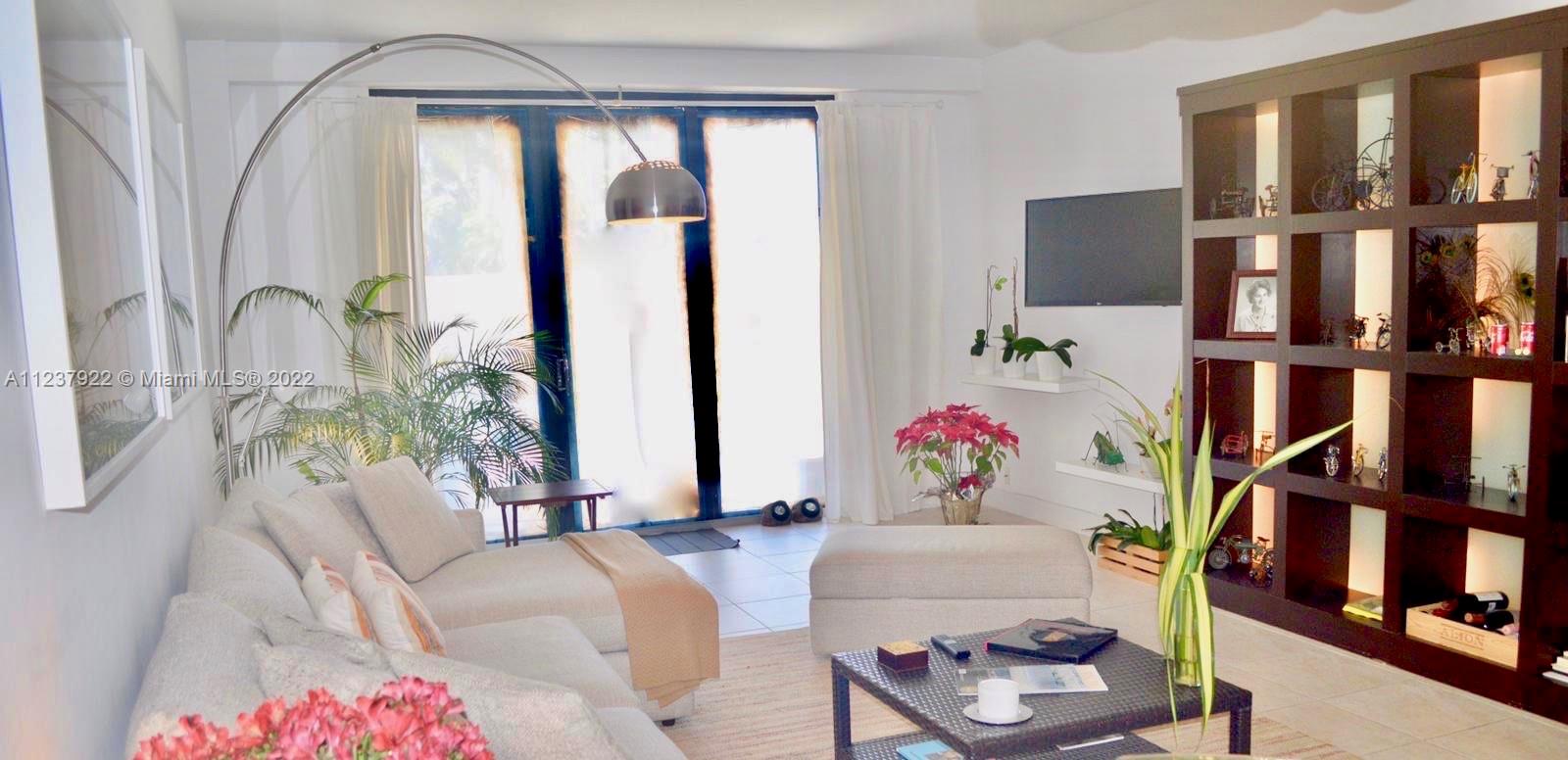 151 Crandon Boulevard, Unit 127 Key Biscayne, FL 33149 - Photo 4 of 30 a living room with furniture and a floor to ceiling window