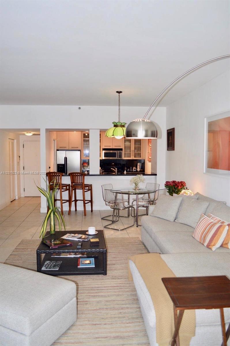 151 Crandon Boulevard, Unit 127 Key Biscayne, FL 33149 - Photo 5 of 30 a living room with furniture kitchen view and a wooden floor
