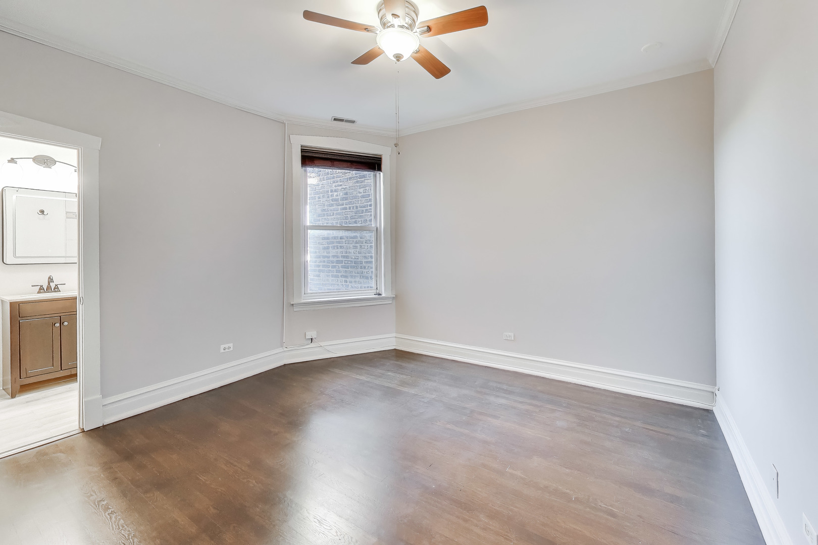 1447 West Warner Avenue, Unit 3W Chicago, IL 60613 - Photo 21 of 27 an empty room with wooden floor fan and windows