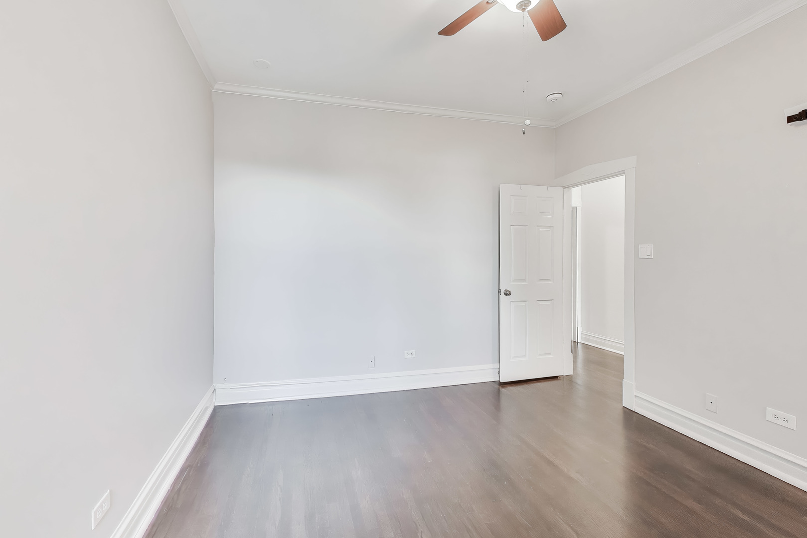 1447 West Warner Avenue, Unit 3W Chicago, IL 60613 - Photo 22 of 27 an empty room with wooden floor chandelier fan and windows