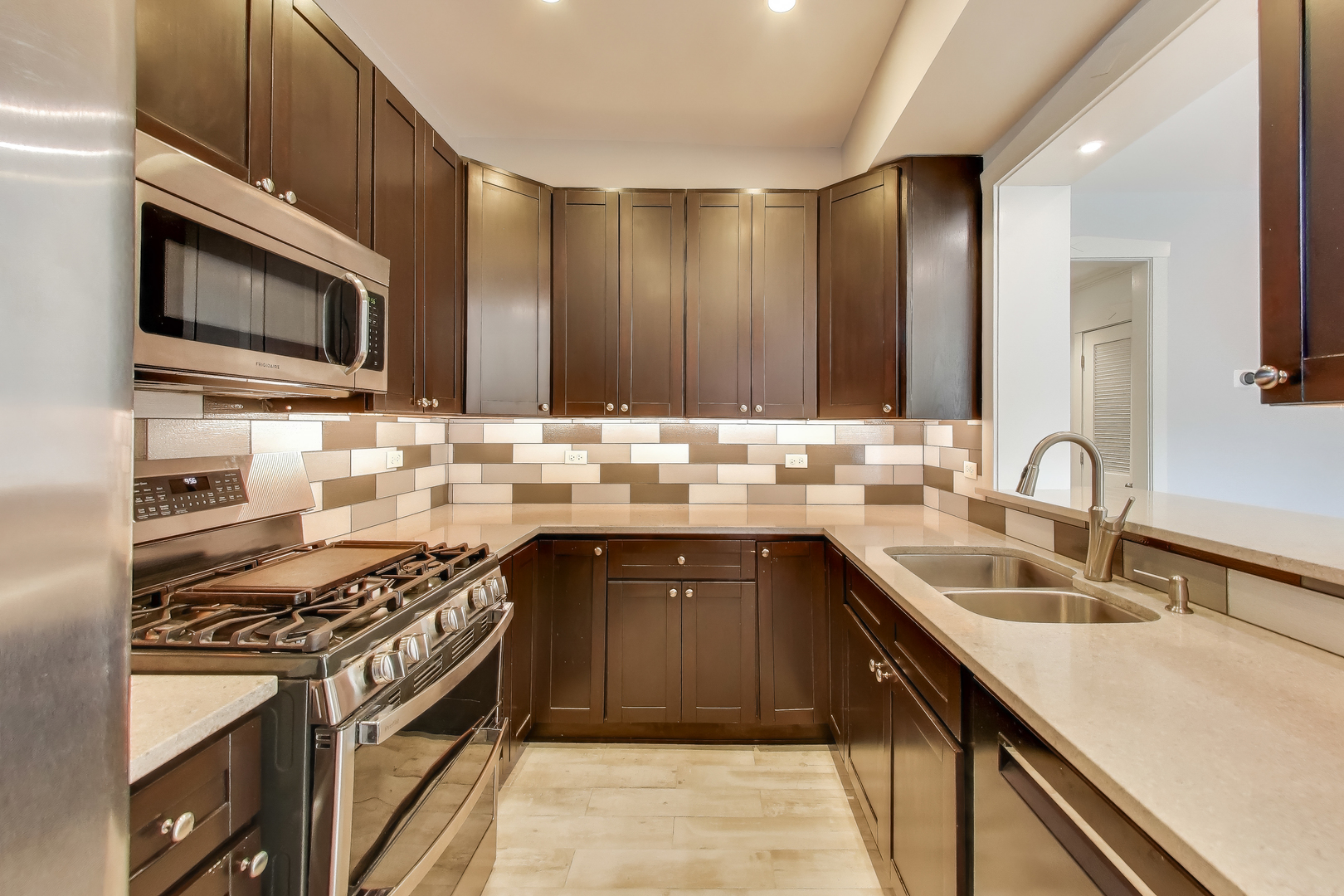 1447 West Warner Avenue, Unit 3W Chicago, IL 60613 - Photo 9 of 27 a kitchen with stainless steel appliances a sink stove and microwave
