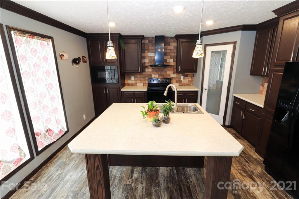 4024 Steen Road Mount Croghan, SC 29727 - Photo 16 of 37 a kitchen with stainless steel appliances wooden floor dining table and chairs