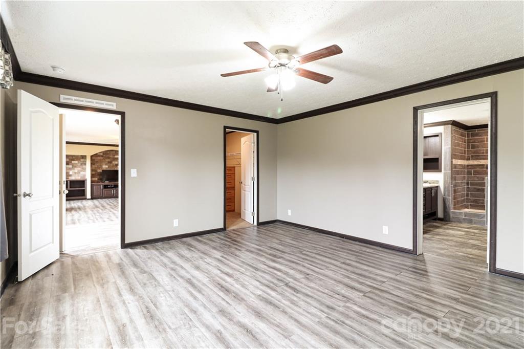 4024 Steen Road Mount Croghan, SC 29727 - Photo 6 of 37 an empty room with wooden floor chandelier fan and windows