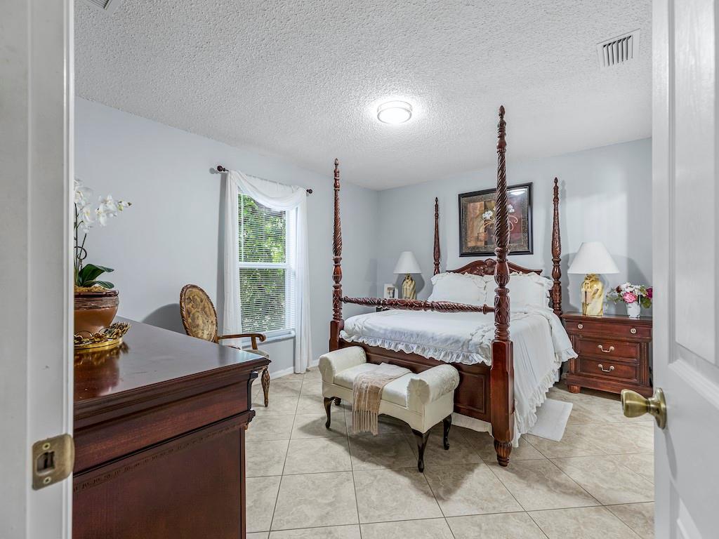 941 Southwest Longfellow Road Port St. Lucie, FL 34953 - Photo 14 of 36 a bedroom with furniture and a window