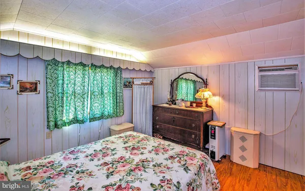 a bedroom with a bed window and a dresser