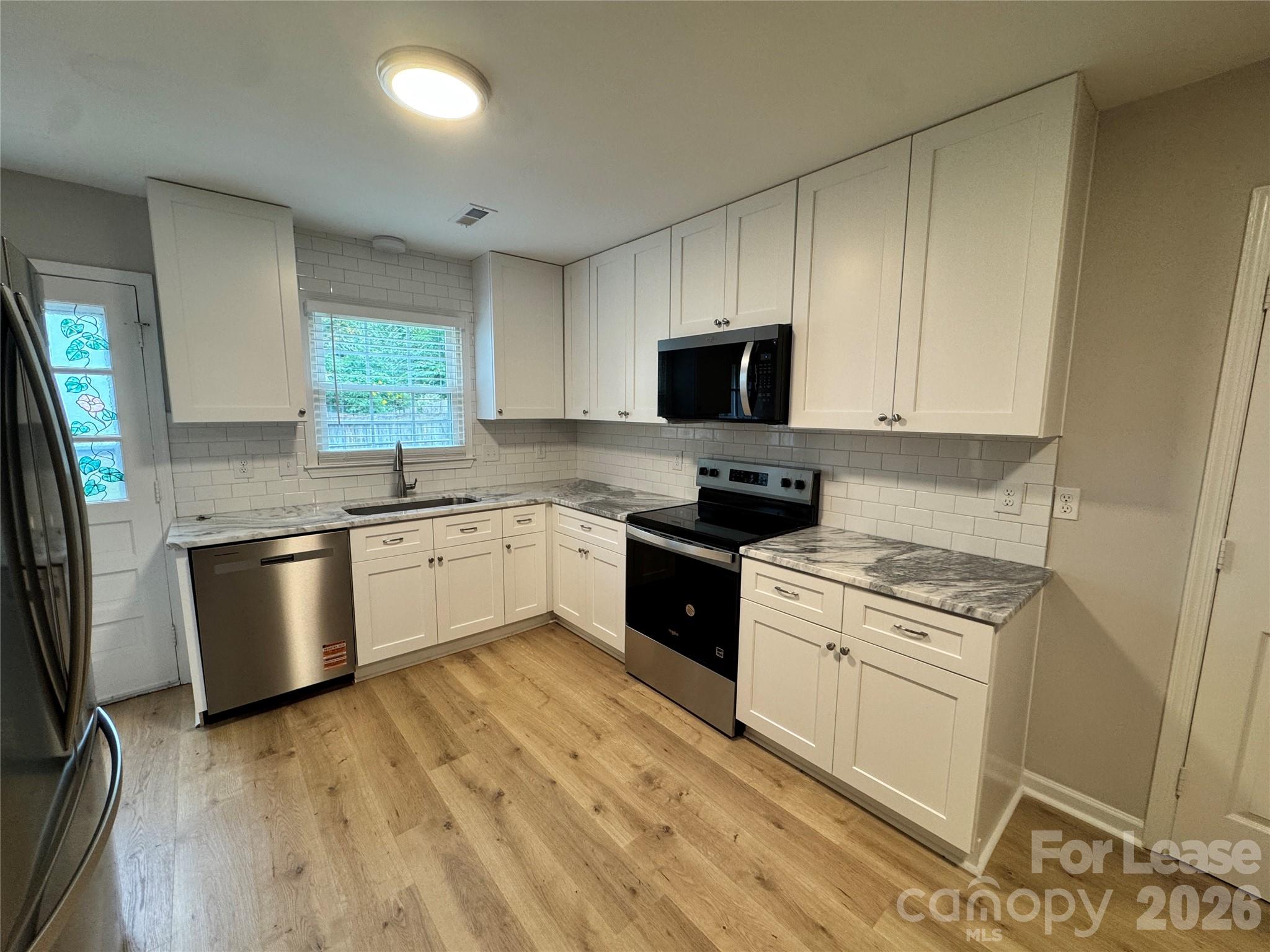 6314 Harrisburg Road Charlotte, NC 28227 - Photo 2 of 16 a kitchen with a stove a sink and a microwave