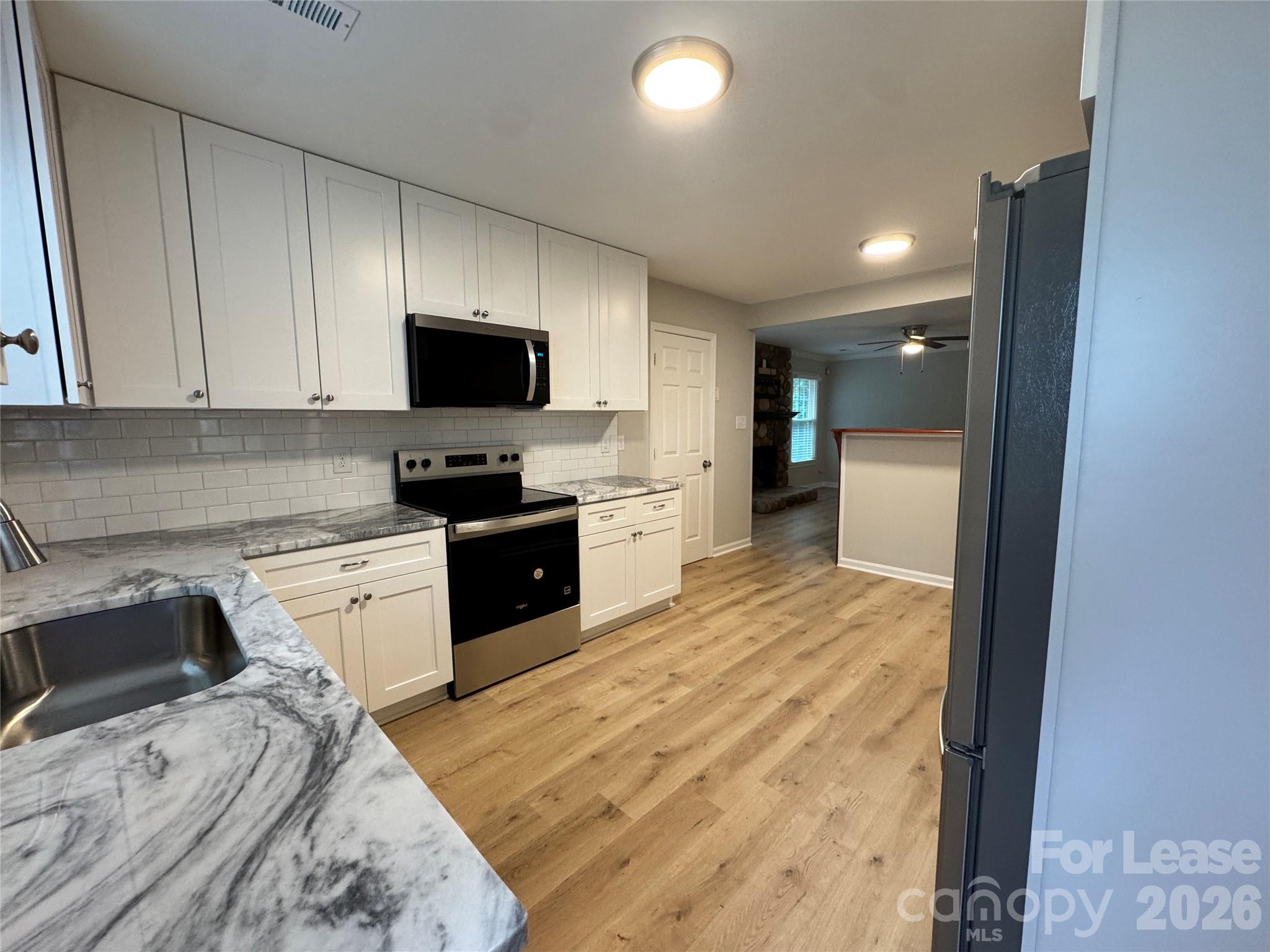6314 Harrisburg Road Charlotte, NC 28227 - Photo 4 of 16 a kitchen with a stove a sink and a refrigerator