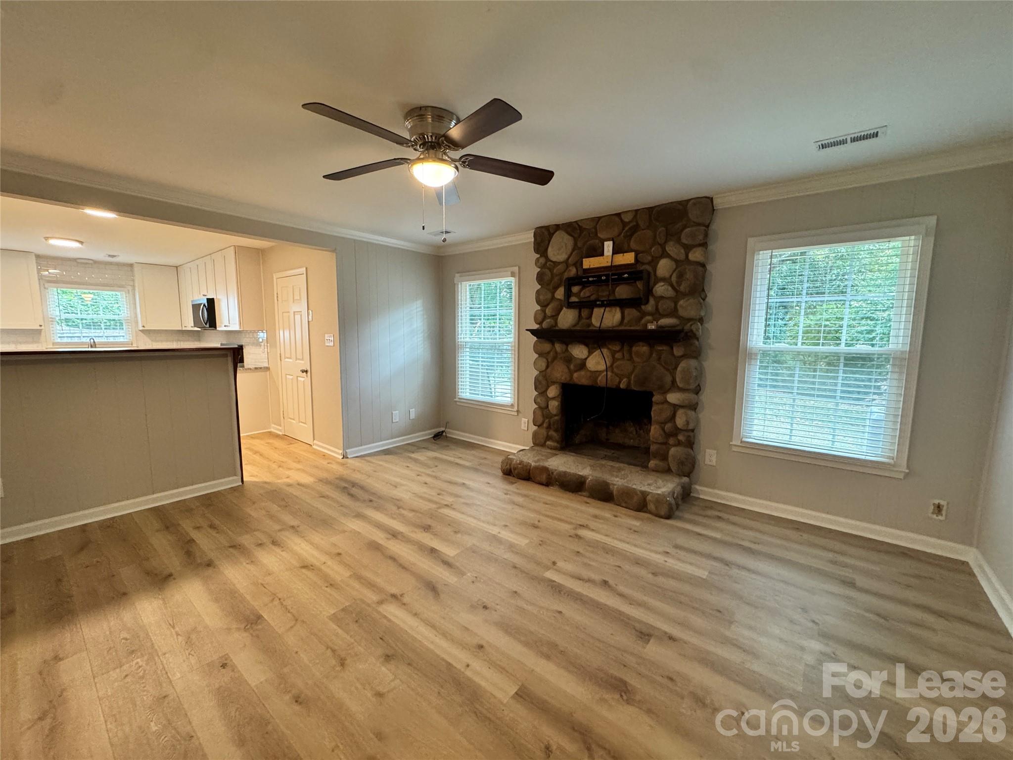 6314 Harrisburg Road Charlotte, NC 28227 - Photo 8 of 16 an empty room with windows fireplace and wooden floor