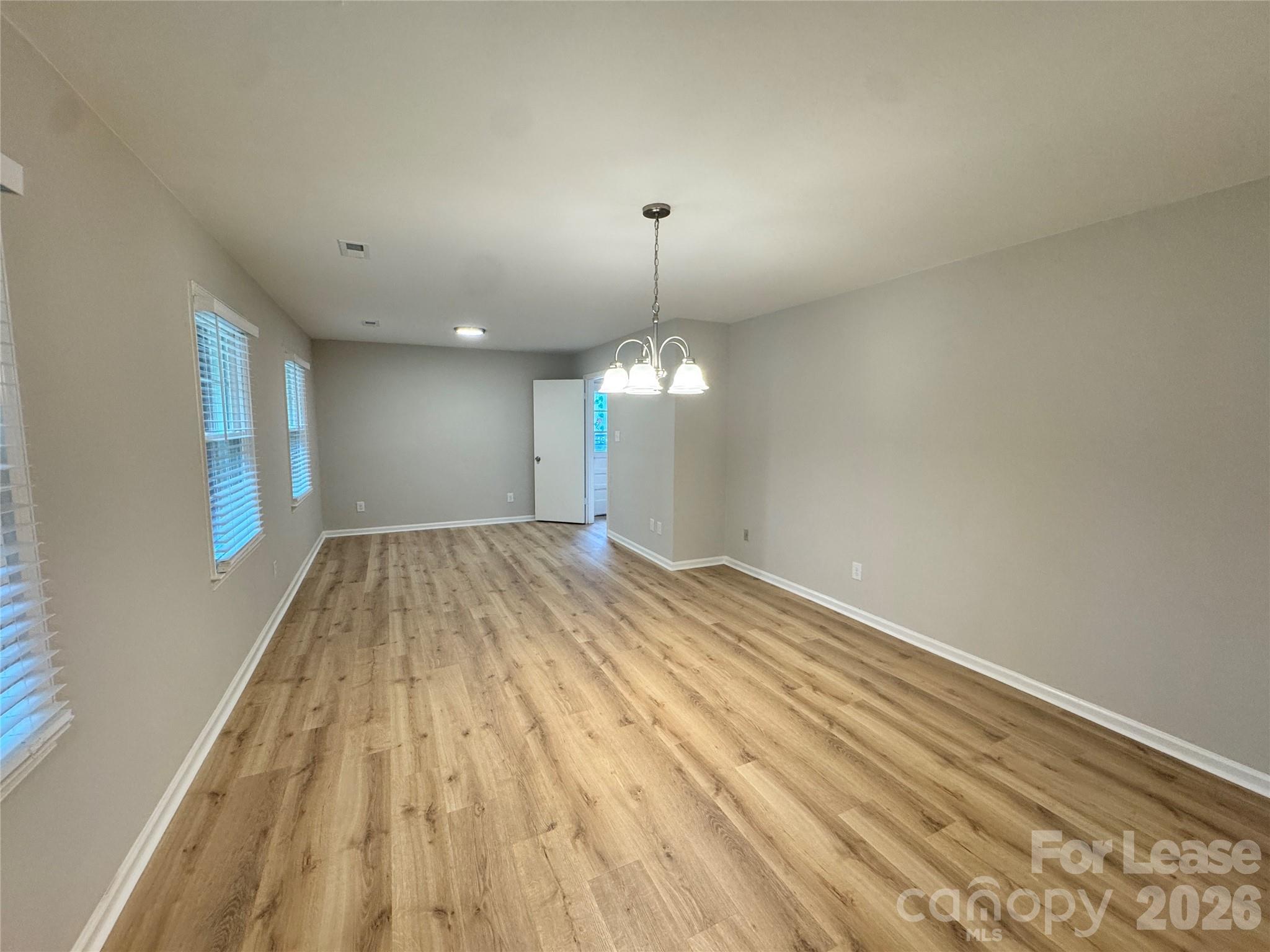 6314 Harrisburg Road Charlotte, NC 28227 - Photo 9 of 16 a view of a room with wooden floor and chandelier