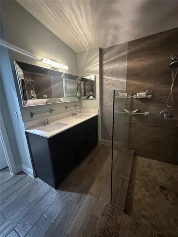 a bathroom with a sink mirror and shower
