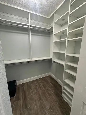 a view of walk in closet with empty racks