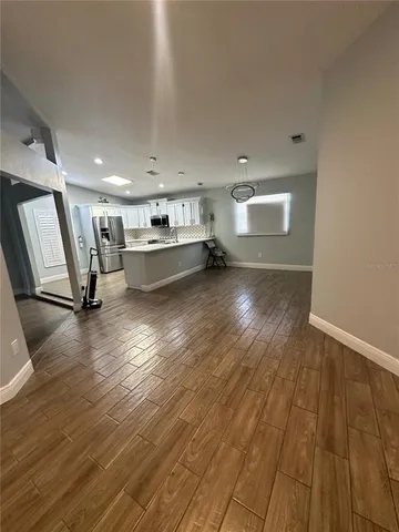 a view of a kitchen with wooden floor and a sink