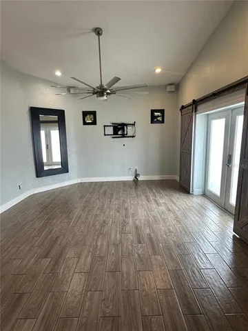 a view of a livingroom with wooden floor and a ceiling fan