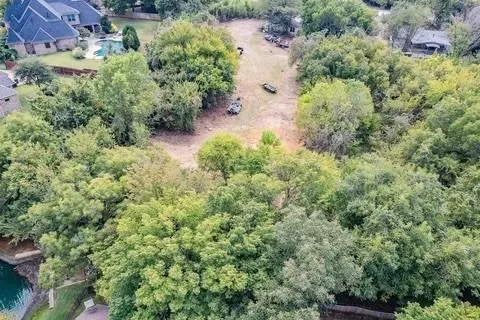 an aerial view of residential house with outdoor space and trees all around