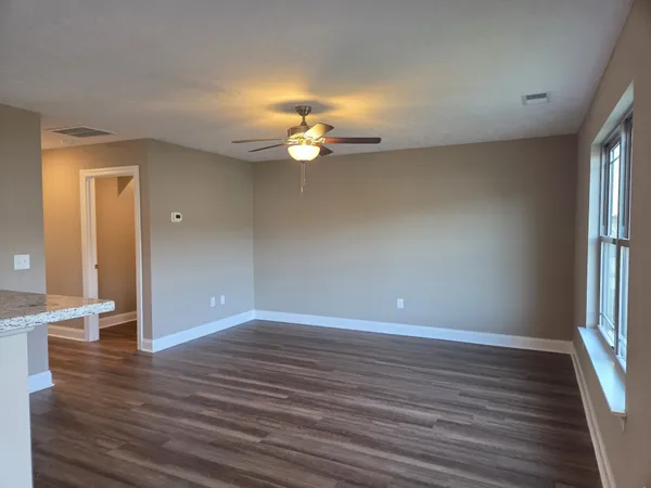 wooden floor in an empty room with a window