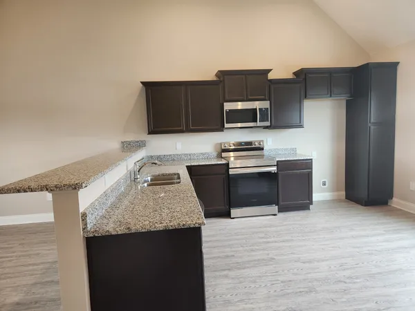 a kitchen with stainless steel appliances granite countertop a sink stove and refrigerator
