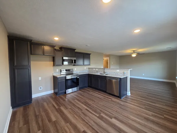 a large kitchen with a large counter top and stainless steel appliances