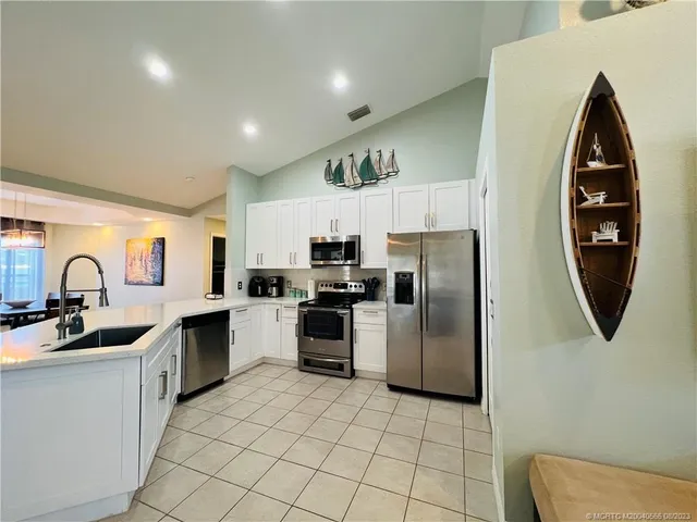a kitchen with white cabinets and stainless steel appliances