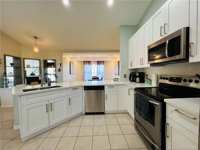 a kitchen with stainless steel appliances granite countertop white cabinets a refrigerator and a stove
