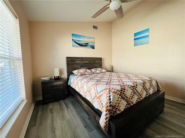 a bedroom with two beds and wooden floor