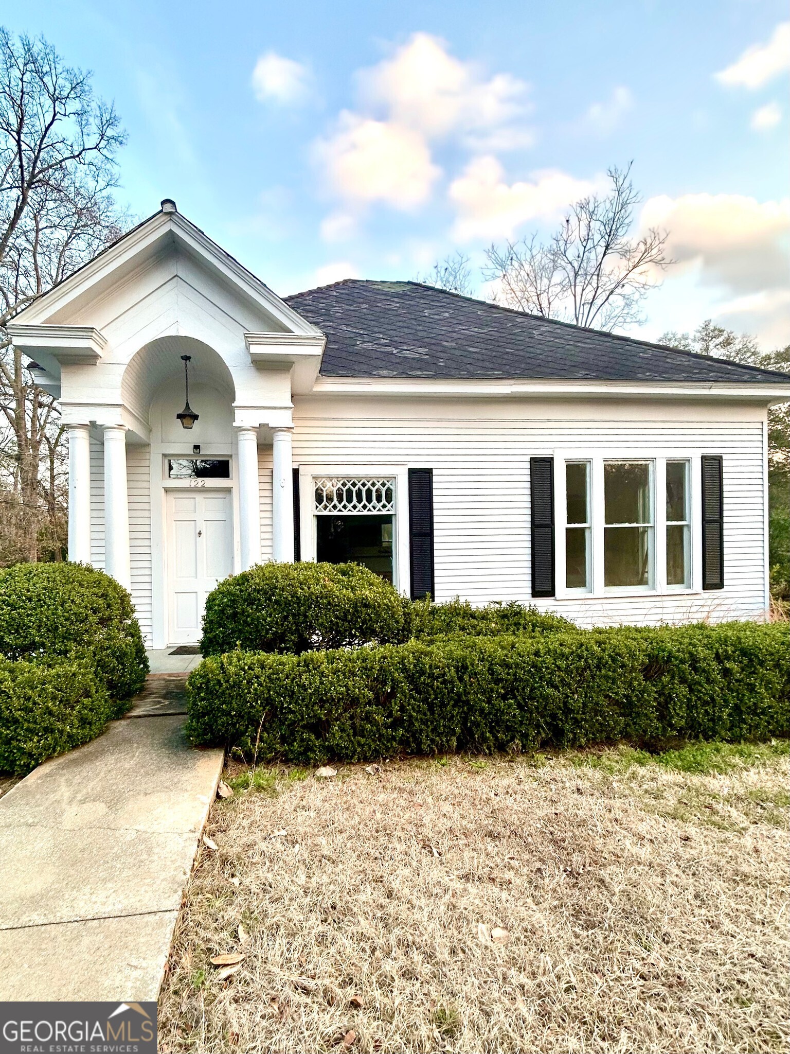 a front view of a house with a garden