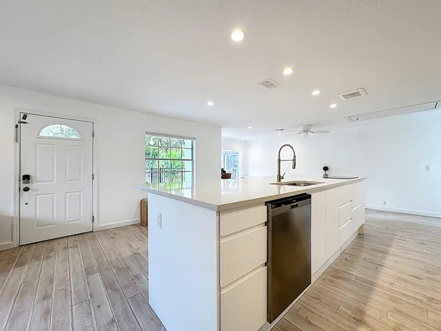 a large kitchen with stainless steel appliances a large counter top