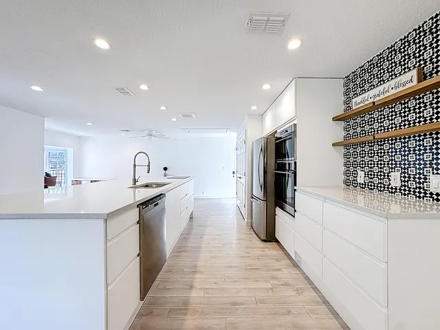 a kitchen with stainless steel appliances a refrigerator and a stove top oven