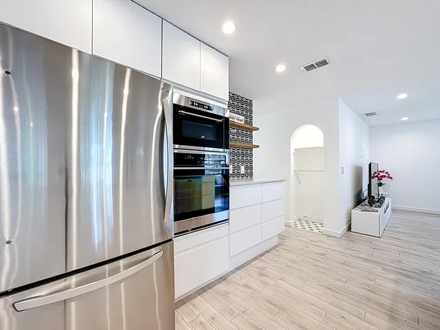 a kitchen with stainless steel appliances kitchen island granite countertop a sink and cabinets