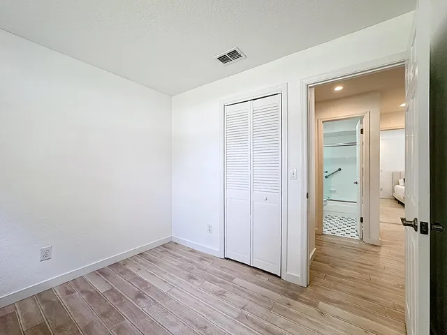 a bedroom with a bed and wooden floor