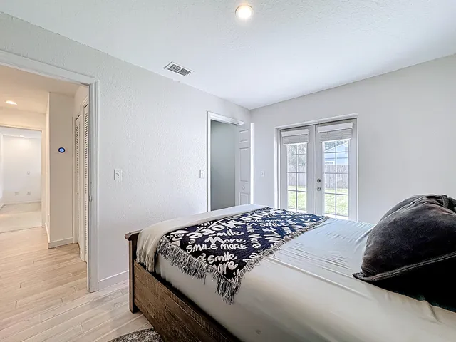 a bedroom with a bed and a large window