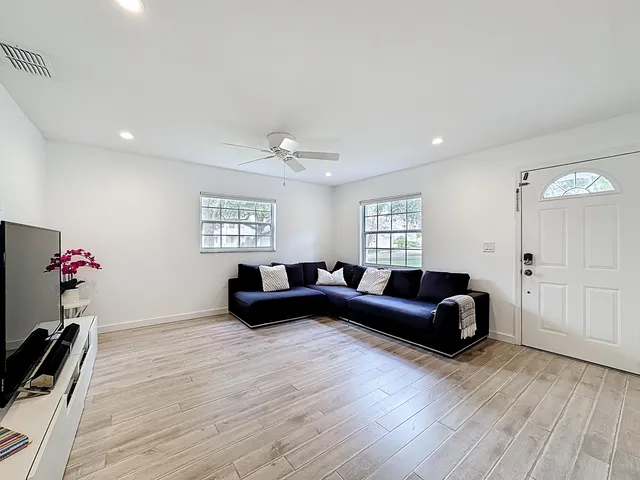 a living room with furniture and wooden floor
