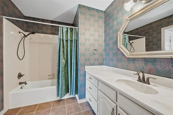 a bathroom with a granite countertop sink a mirror a shower and a bathtub