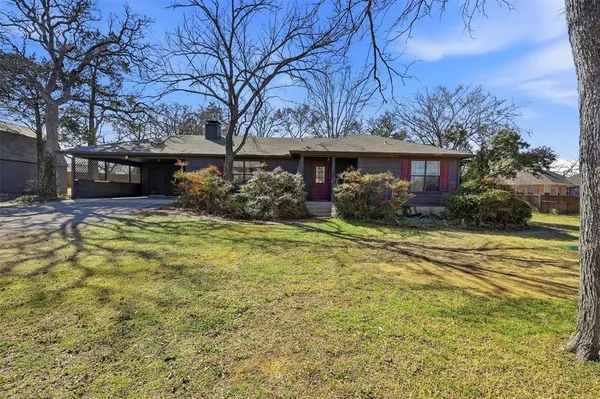 a view of house with yard and trees in front of it