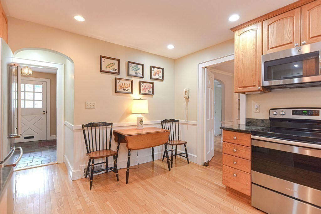 11 Wilde Road Wellesley, MA 02481 - Photo 11 of 26 a kitchen with stainless steel appliances kitchen island granite countertop a table chairs in it and wooden floors