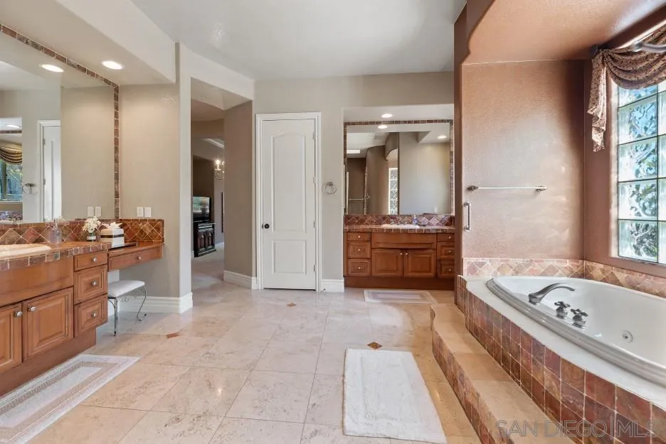 14032 Lake Poway Road Poway, CA 92064 - Photo 23 of 51 a bathroom with a tub a sink and a large mirror