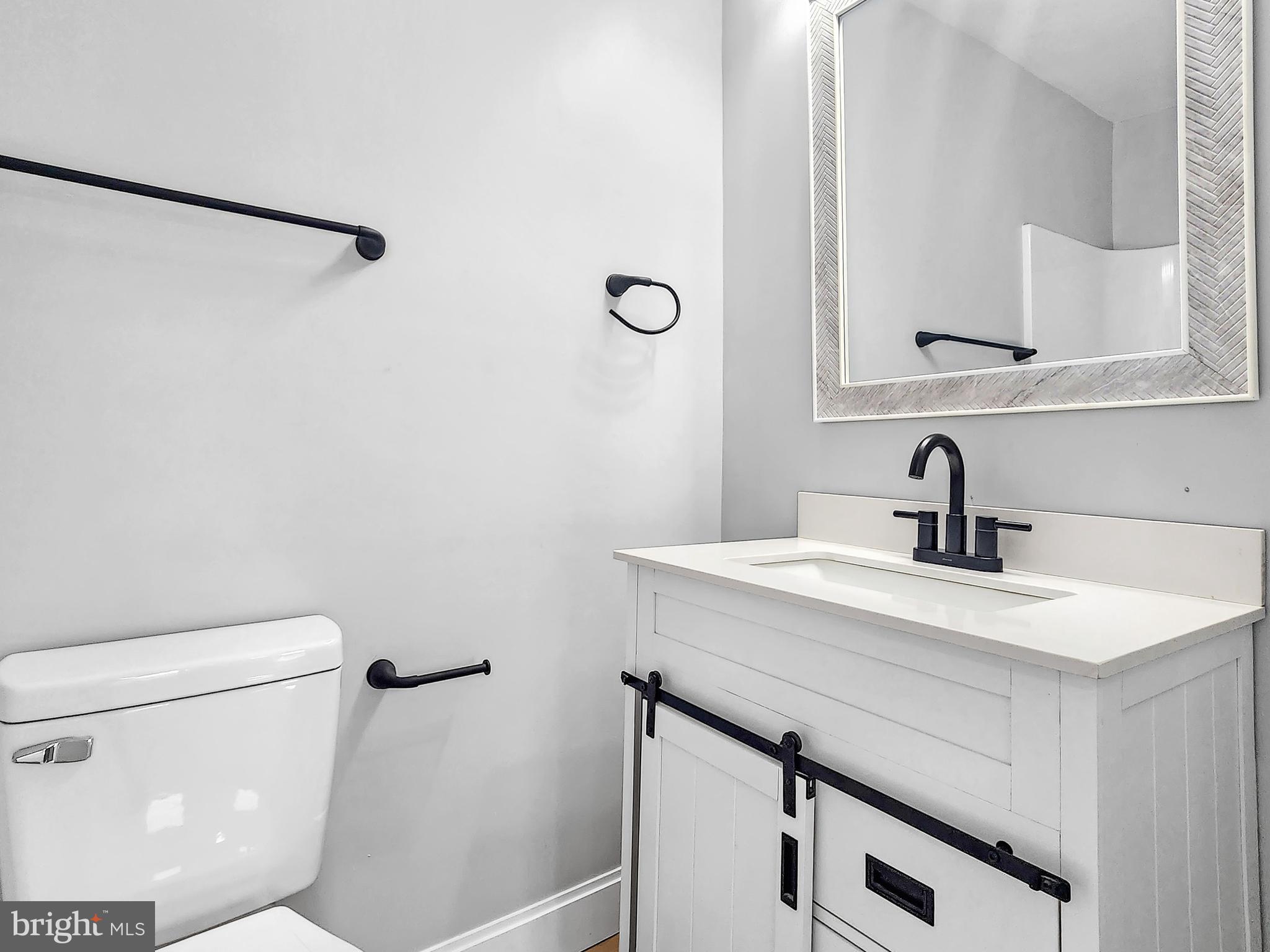 30181 Temperanceville Road Temperanceville, VA 23442 - Photo 27 of 41 a bathroom with a sink a toilet and a mirror
