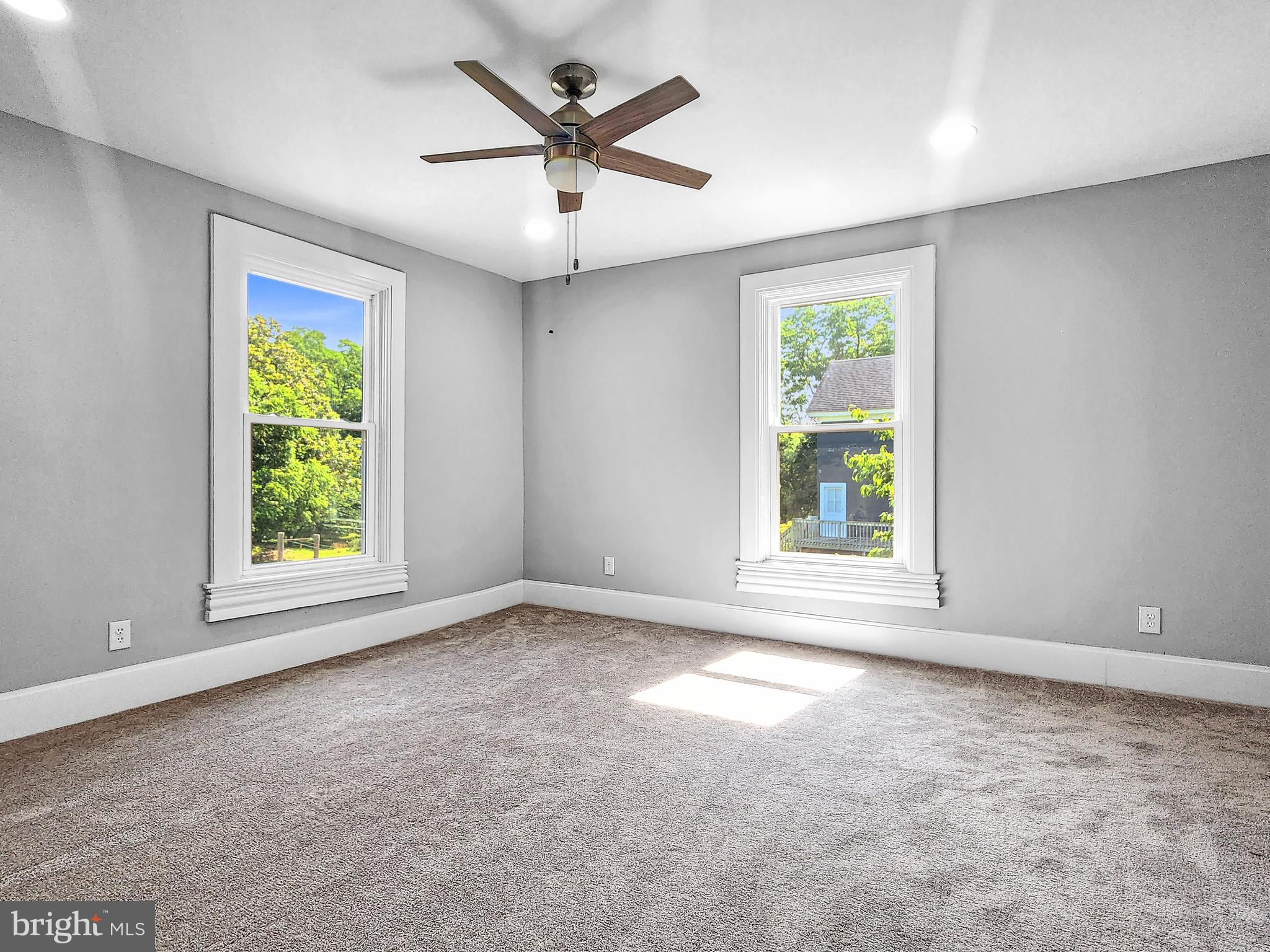 30181 Temperanceville Road Temperanceville, VA 23442 - Photo 34 of 41 an empty room with windows and a ceiling fan