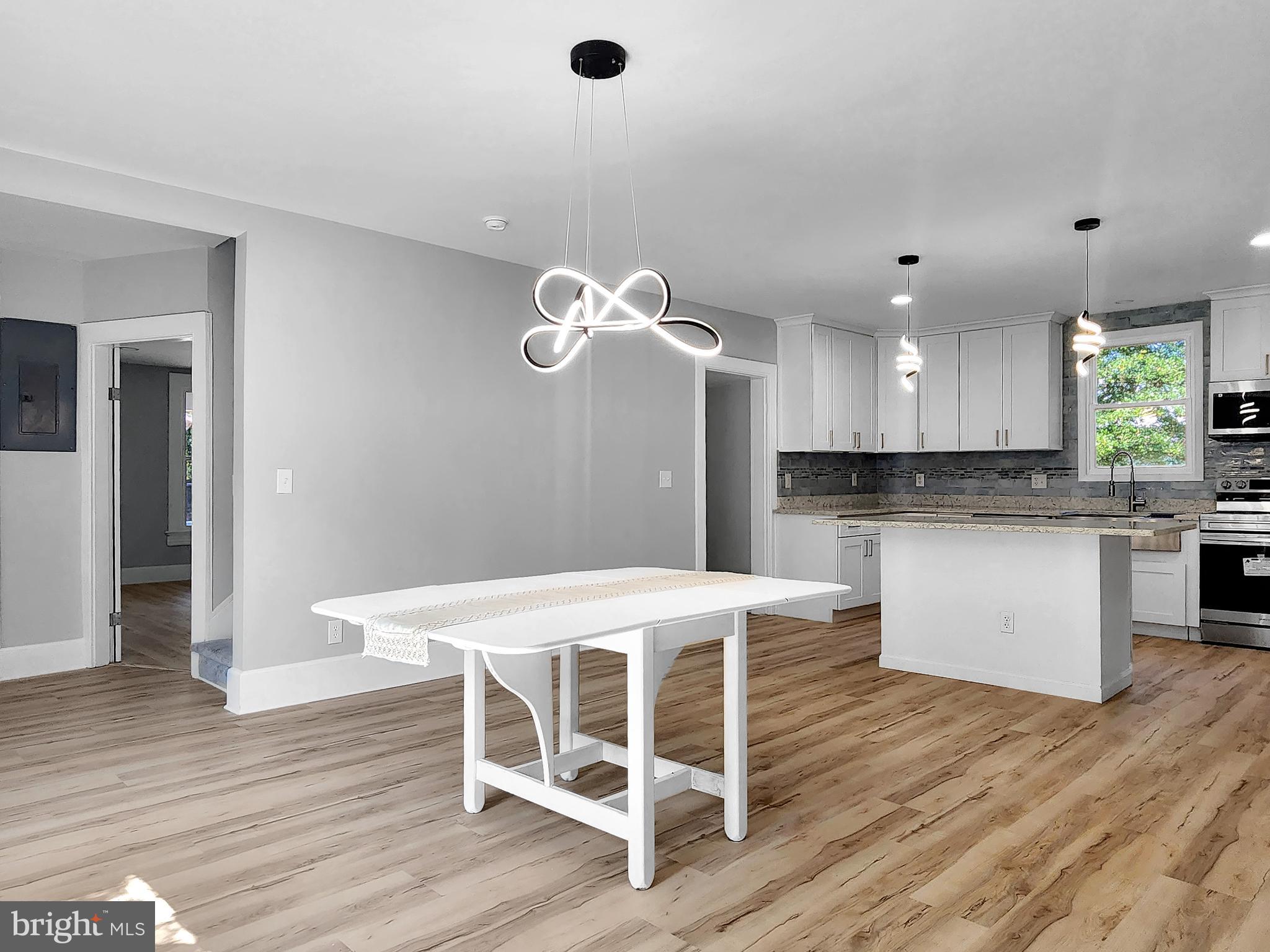 30181 Temperanceville Road Temperanceville, VA 23442 - Photo 8 of 41 a kitchen with kitchen island stainless steel appliances a dining table chairs and wooden floor